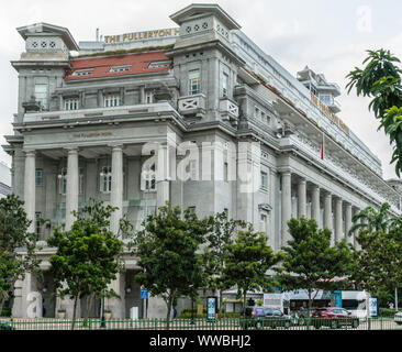 Singapur - März 20, 2019: Die massiven Gebäude aus dem 19. Jahrhundert mit Säulen an der Mündung des Singapore River ist das Fullerton Hotel gegen Silber Stockfoto