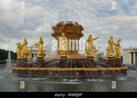 Die Freundschaft der Nationen (Freundschaft der Völker) Brunnen auf dem Hauptplatz im Messegelände VDNH (Ausstellung der Errungenschaften der Volkswirtschaft) in Moskau, Russland. Der Brunnen wurde von sowjetischen Architekten Konstantin Topuridze mit 16 vergoldeten Statuen der Nationen der Sowjetunion durch sowjetischen Bildhauer Zinaida Bazehenova, Alexey Teneta, Iosif Chaykov, Zoya Ryleyeva und andere in 1954 gebaut wurde eingerichtet. Der Brunnen ist auch bekannt als die Goldene Garbe. Stockfoto