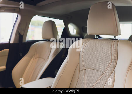Auto innen Fahrer statt. Innenraum der Prestige modernes Auto. Vordersitze mit Lenkrad, Armaturenbrett. Beige Cockpit mit Metall deko Panoramablick roo Stockfoto