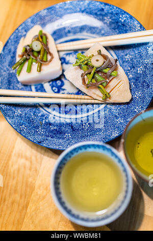 Traditionelle japanische Platte auf Restaurant Holztisch mit Feder gemüsegericht der takenoko Bambussprossen, Gummersbach Wildkräuter mit Stäbchen, Sencha Stockfoto