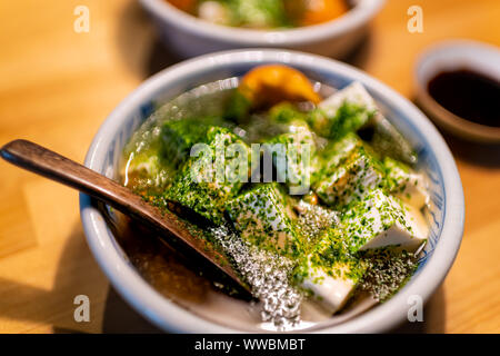 Traditionelle japanische Schüssel Löffel aus Holz auf Restaurant Küche Tisch mit Frühling Gemüsesuppe Gericht von Honig Pilze, gewürfelt Tofu in Sojasauce und Aon Stockfoto