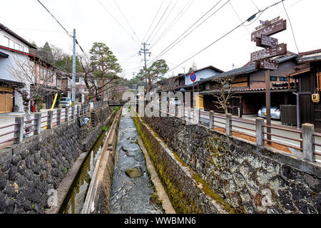 Takayama, Japan - April 7, 2019: Japanische ländlichen historische Stadt in der Präfektur Gifu mit traditionellen machiya Holzhäuser auf Straße, Brücke über doppelzi. Stockfoto