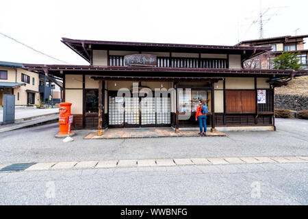 Takayama, Japan - April 7, 2019: historische Stadt in der japanischen Präfektur Gifu mit traditionellen machiya Holzhaus und Frau touristische stehend durch lokale c Stockfoto