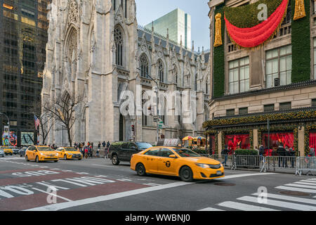 New York City, NY, USA - Dezember, 2018 - Straßen von Manhattan, klassischen gelben Taxi die Fifth Avenue Kreuzung in der Nähe von Saks Fifth Avenue Stockfoto