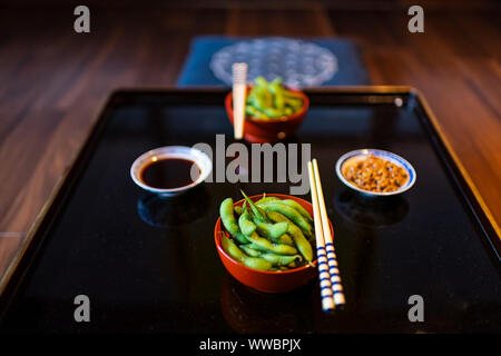 Traditionelle japanische Platte Schüssel in Restaurant oder Ryokan kaiseki mit gemüsegericht gekochte Salz edamame, natto und Sojasauce auf Platte mit chopstic Stockfoto