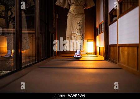 Traditionelle japanische Haus Ryokan, Tatami Matten, Papier und Shoji Schiebetüren Türen, Frau im Kimono und geta Tabi Socken Schuhe Wandern in Korridor Hall Stockfoto