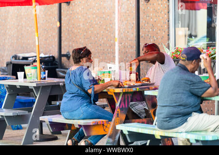 Mobile, USA - 21. April 2018: Alte Dauphin street in Alabama berühmten südlichen Stadt mit Bier Bar und Mann Frau trinkt sitzen auf Tischen außerhalb d Stockfoto
