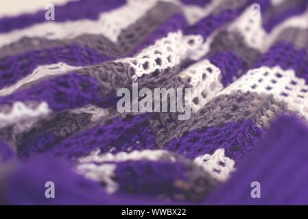 Lila und Weiß Gestreifte Muster Garn häkeln Pullover. Textur Detail Nahaufnahme. Stockfoto