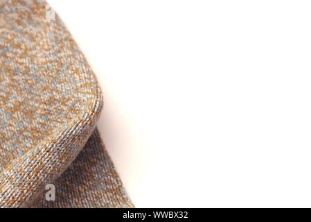 Meliert beige gestrickten Wollpullover auf weißem Hintergrund. Textur Detail Nahaufnahme. Negativer Platz. Stockfoto