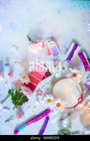 Leere Stickrahmen in Pastelltönen gehalten und mit Blumen und DIY-Tools. Feminine Workplace Konzept Stockfoto