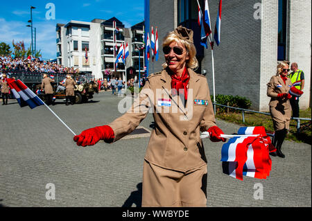 Veghel, Niederlande. 14 Sep, 2019. Eine Frau gesehen, die niederländische Flagge während der Parade. Die 2019 zum Gedenken an 75 Jahre seit der Operation Market Garden stattfand. Operation Market Garden war eine der größten Alliierten Operationen des Zweiten Weltkriegs. Es fand im September 1944 statt. Zu der Zeit, die Alliierten reisten aus Belgien über mehrere Standorte in den Niederlanden, um schließlich in Nimwegen und Arnheim. Niederlande. Credit: SOPA Images Limited/Alamy leben Nachrichten Stockfoto