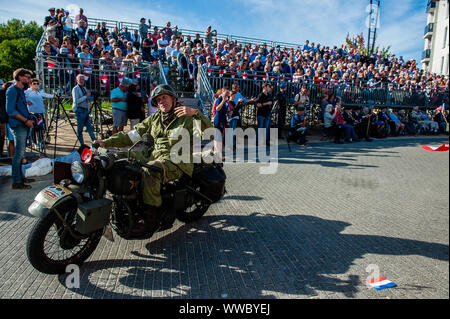 Veghel, Niederlande. 14 Sep, 2019. Ein Mann auf einem Motorrad gesehen wird, winken die Masse während der Parade. Die 2019 zum Gedenken an 75 Jahre seit der Operation Market Garden stattfand. Operation Market Garden war eine der größten Alliierten Operationen des Zweiten Weltkriegs. Es fand im September 1944 statt. Zu der Zeit, die Alliierten reisten aus Belgien über mehrere Standorte in den Niederlanden, um schließlich in Nimwegen und Arnheim. Niederlande. Credit: SOPA Images Limited/Alamy leben Nachrichten Stockfoto