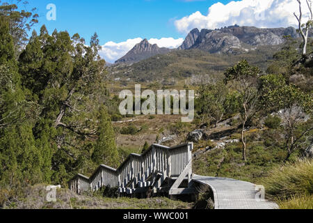 Boardwalk auf Wanderweg mit Bergen im Hintergrund, Teil der Overland Track, Frühling, Cradle Mountain NP, Tasmanien Stockfoto