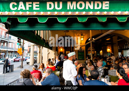 New Orleans, USA - 22. April 2018: Die Menschen essen Bestellen im Cafe Du Monde restaurant, essen beignet Puderzucker Donuts, Kaffee trinken, Chicorée, wa Stockfoto