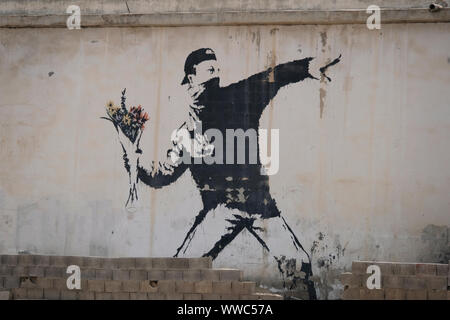 Die ikonischen Banksy "Rage, Blume Werfer" oder "Blume Bomber", schildert eine palästinensische Demonstranten werfen einen Strauß Blumen von Banksy an einer Wand auf der Seite einer Garage auf der Hauptstraße von Beit Sahour eine palästinensische Stadt östlich von Bethlehem im Central West Bank gemalt. Palästinensische Gebiete, Israel Stockfoto