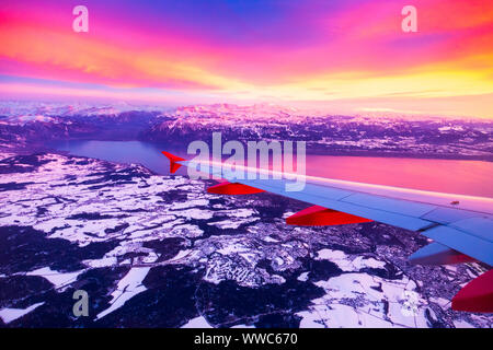 Blick aus dem Flugzeug Fenster während der Sonnenuntergang über der Alpen in der Schweiz Stockfoto