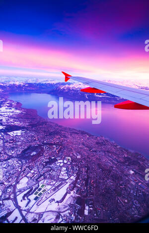 Blick aus dem Flugzeug Fenster während der Sonnenuntergang über der Alpen in der Schweiz Stockfoto