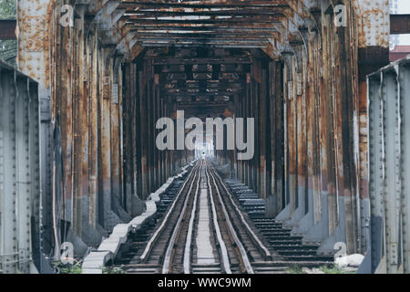 Bügeleisen Eisenbahnbrücke Perspektive mit einer menschlichen Silhouette in der Mitte in Hanoi, Vietman Stockfoto