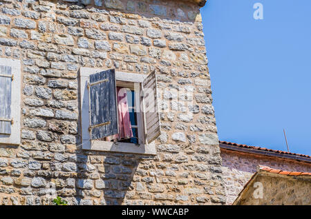 Steinmauer mit Fensterläden aus Holz am Fenster. Stockfoto