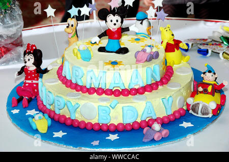 Bunte Geburtstag Kuchen mit wenig Comic-figuren auf der Oberseite dekoriert. Stockfoto