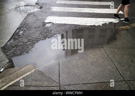 Regenwasser Pfütze auf der Magnificent Mile auf einem nassen stürmischen bewölkten Tag Chicago Illinois USA Stockfoto