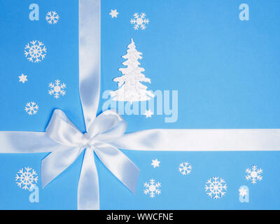 Weißer Bogen, Schneeflocken, Tanne auf blauem Hintergrund. Winterurlaub Konzept Stockfoto
