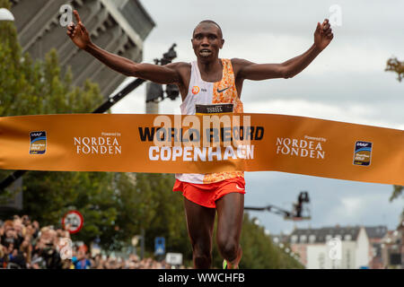 Geoffrey Kamworor zerschlägt den Halbmarathon Weltrekord, als er die Ziellinie während der 2019 Halbmarathon in Dänemark Kopenhagen überquert. Stockfoto