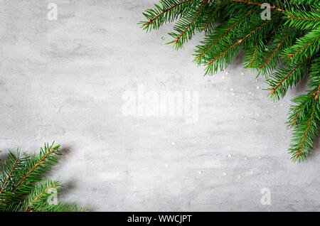 Tannenzweigen Grenze auf grauem Hintergrund, Weihnachten Kulisse. Stockfoto