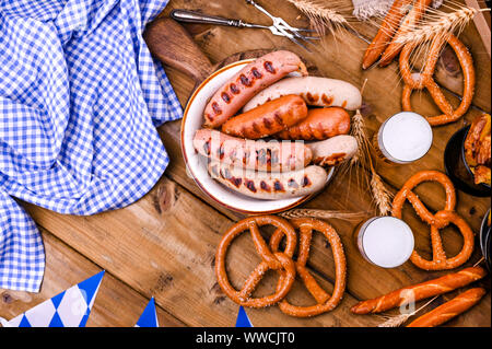 Traditionelle deutsche Würstchen für das Bierfest. Zwei Gläser Bier. Holz Hintergrund und Dekor. Ansicht von oben Stockfoto