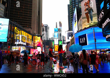 Verkehr der Fußgänger, Radfahrer, Autos schleppt durch den Times Square an einem regnerischen Nachmittag. Manhattan am 31. Juli 2019 in New York, USA. (Foto durch Stockfoto