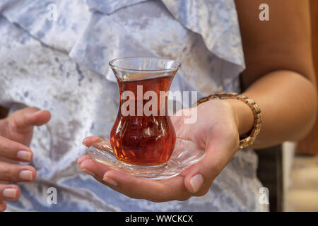 Nahaufnahme von köstlichen roten Türkischen Tee mit traditionellen birnenförmigen Glas in der Frau die Hand, Türkei Stockfoto