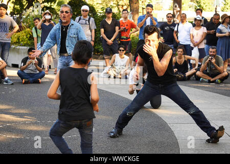 Ein Mann und ein Junge von The Strangers, einem Tokyo Rockabilly Club, tanzen an einem sonnigen Sommersonntagnachmittag im Yoyogi Park in Shibuya, Tokio, Japan. Stockfoto