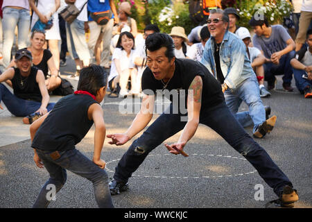 Ein Mann und ein Junge von The Strangers, einem Tokyo Rockabilly Club, tanzen an einem sonnigen Sommersonntagnachmittag im Yoyogi Park in Shibuya, Tokio, Japan. Stockfoto