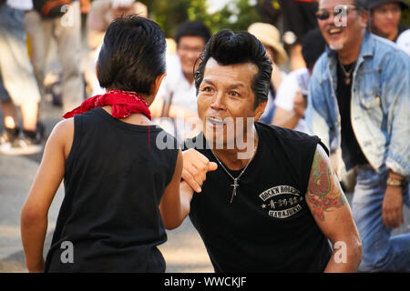 Ein Mann und ein Junge von The Strangers, einem Tokyo Rockabilly Club, tanzen an einem sonnigen Sommersonntagnachmittag im Yoyogi Park in Shibuya, Tokio, Japan. Stockfoto