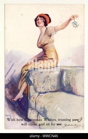 Anfang 1900 WW1 Ära illustrierte Weihnachtsgrüße Postkarte der glamourösen, flirtatious Frau, ein wenig frech zu der Zeit als zeigen Knöchel und halten die Mistel, 1914, Großbritannien Stockfoto