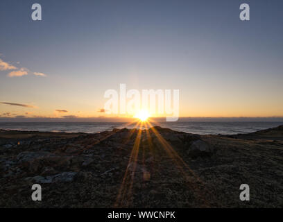 Schöne Sicht auf das Meer in Island mit Sonnenuntergang am Horizont Stockfoto