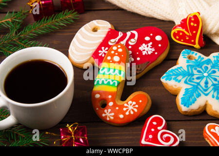 Tasse Kaffee und Weihnachtsplätzchen, Lebkuchen und Spielzeug auf Holztisch. Stockfoto