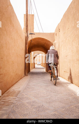 Ein Mann, sein Fahrrad in einer kleinen Straße von Shiraz, Iran Stockfoto