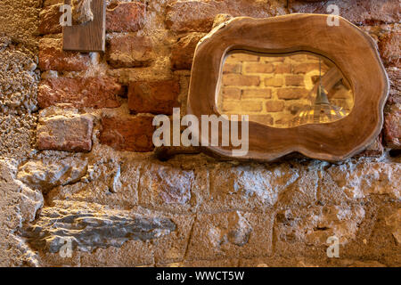 Spiegel mit Rahmen aus Holz. Alten Ziegel Wand im Hintergrund. Stockfoto