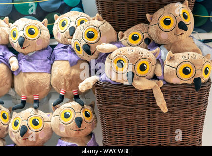 Spielzeug von kleinen Eulen in einem großen Weidenkorb. Stockfoto