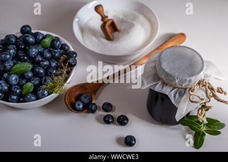 Huckleberry Jam close-up. Blueberry und Zucker und Löffel aus Holz in einer Schüssel in die Küche. Stockfoto