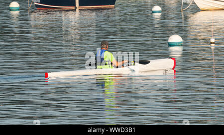 Ein Mann ist bei einem Morgen Kajak um angelegten Boote an der Nordküste von Long Island in der Bucht. Stockfoto