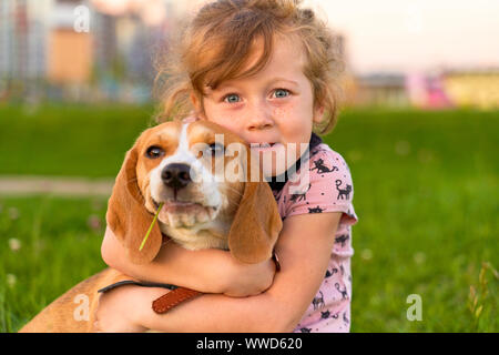 Sommersprossiges Mädchen umarmt freudig ihre beste Freundin. Stockfoto