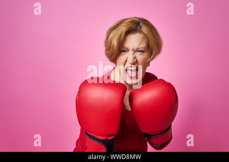 Frau in Boxhandschuhe im Alter. Das Konzept der Kampf gegen das Alter. Stockfoto