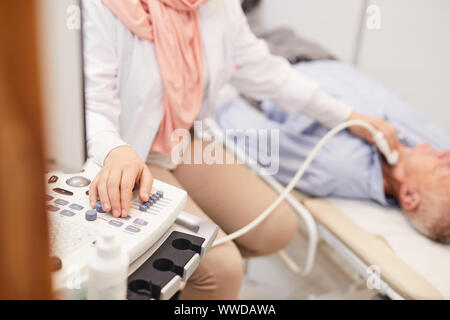 Nahaufnahme des unkenntlich Ärztin mit Ultraschall Maschine während der Prüfung älterer Patienten in der Klinik, Kopie Raum Stockfoto