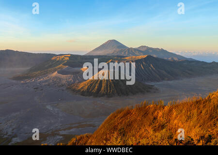 Sonnenaufgang in vulkanische Caldera in Bromo Tengger Semeru National Park. Morgen Sonnenstrahlen die Gipfel der Vulkane, Berge und Krater Wappen beleuchten. Stockfoto