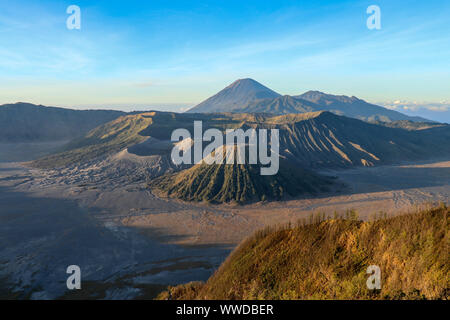 Sonnenaufgang in vulkanische Caldera in Bromo Tengger Semeru National Park. Morgen Sonnenstrahlen die Gipfel der Vulkane, Berge und Krater Wappen beleuchten. Stockfoto