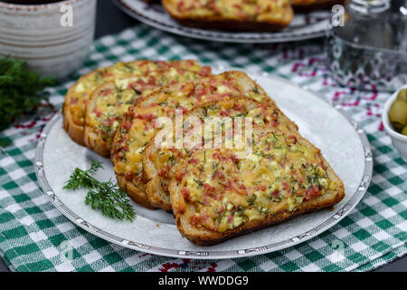 Hausgemachte heiße Sandwiches mit Käse und Wurst in eine Platte auf einem karierten Tischdecken, horizontale Ausrichtung Stockfoto