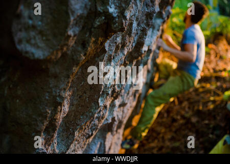 Junge Menschen aktiv Sport Klettern am Felsen während Bouldern im freien Training auf warmen Sonnenuntergang Stockfoto