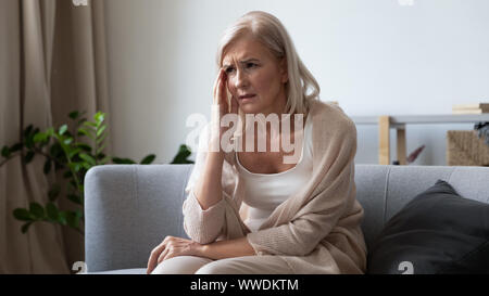 Unglücklich, reife Frau berühren Kopf, Gefühl, starke Kopfschmerzen. Stockfoto
